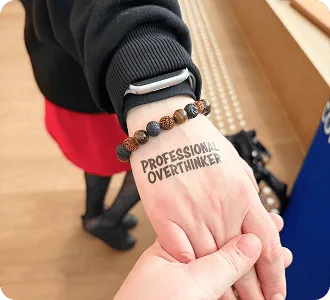 Временная татуировка «Professional Overthinker» на руке участника Baltic-Nordic SEO Summit 2026.
