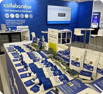Стенд Collaborator на BrightonSEO 2026 с брендированной продукцией, брошюрами и экраном с презентацией.