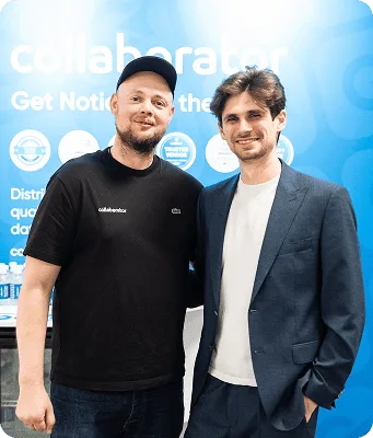 Основатели Collaborator позируют вместе у стенда на BrightonSEO 2026.