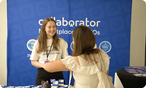 Представитель Collaborator общается с участником конференции у стенда на Croatia SEO Summit.